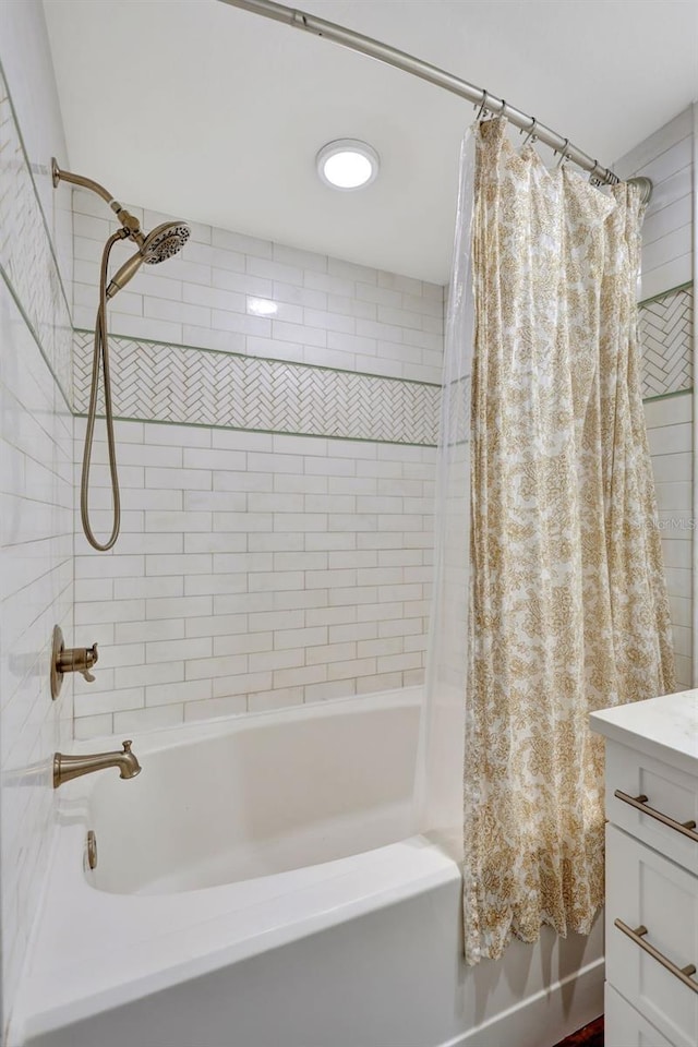 bathroom featuring vanity and shower / bath combination with curtain