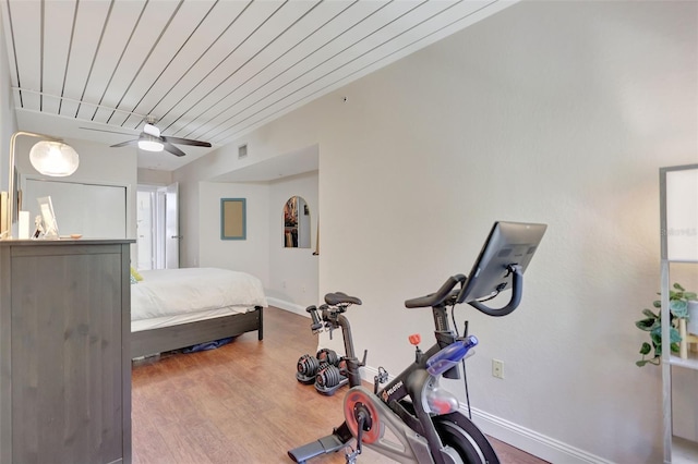 bedroom with wood finished floors, visible vents, and baseboards