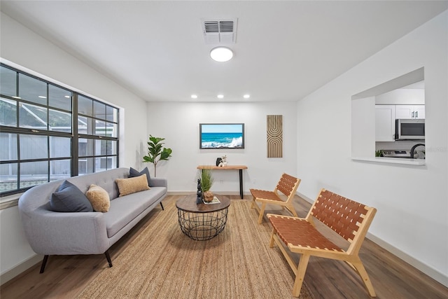 living room featuring wood finished floors, recessed lighting, and baseboards