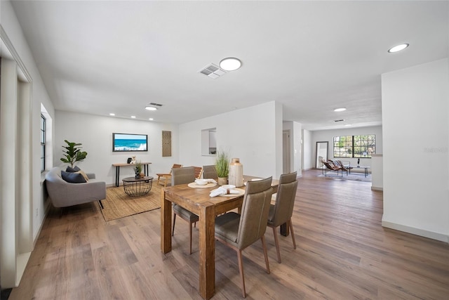 dining room featuring light wood finished floors, recessed lighting, and baseboards