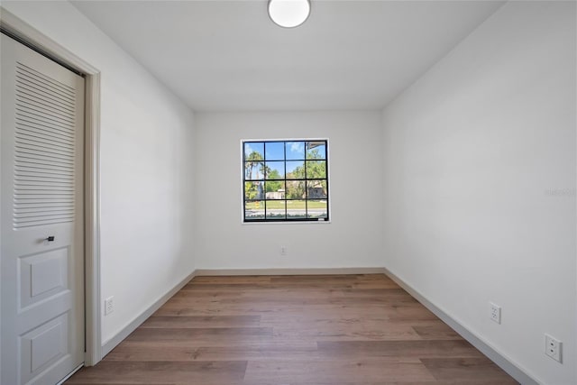 unfurnished room with wood finished floors and baseboards