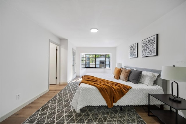 bedroom featuring wood finished floors and baseboards