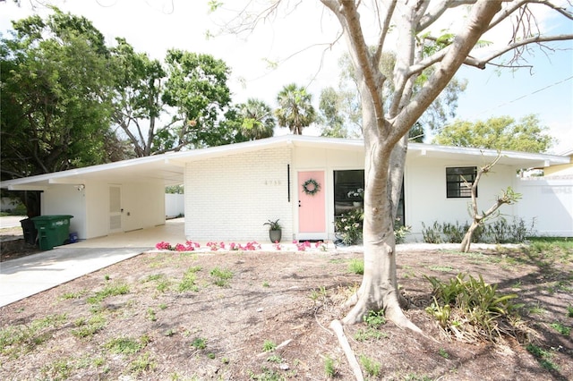 single story home with brick siding, driveway, fence, and an attached carport