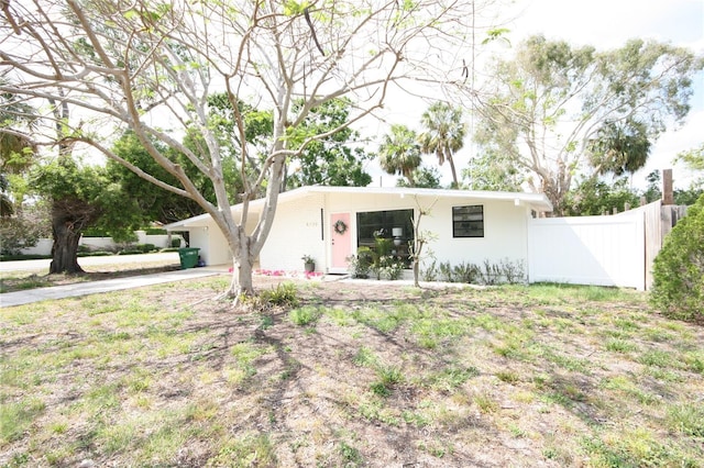 view of front of property with fence and concrete driveway