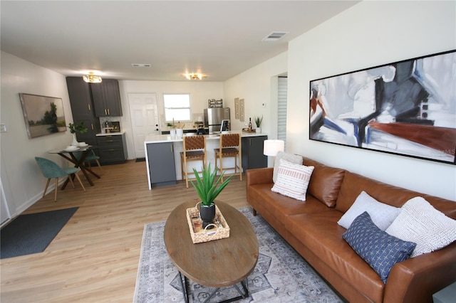 living area featuring visible vents and light wood-style flooring