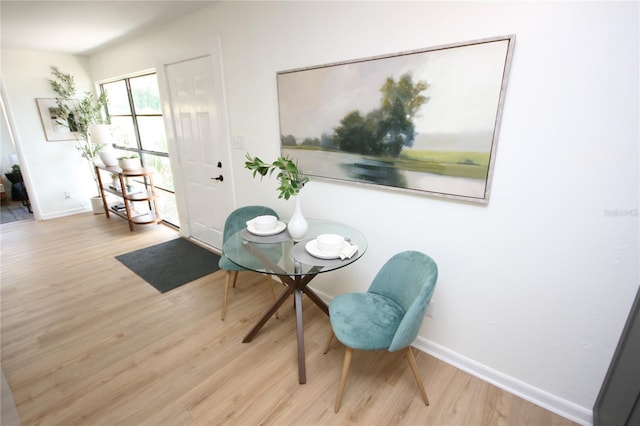 dining space featuring baseboards and wood finished floors