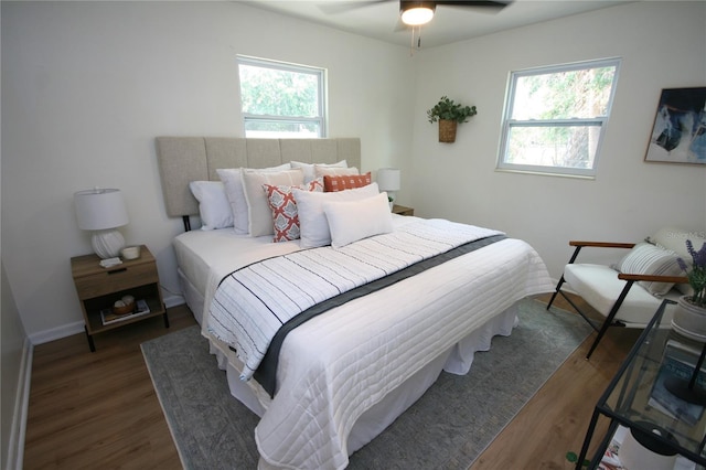 bedroom with ceiling fan, multiple windows, and wood finished floors