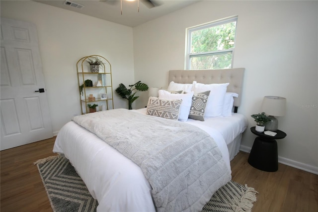 bedroom with visible vents, baseboards, and wood finished floors