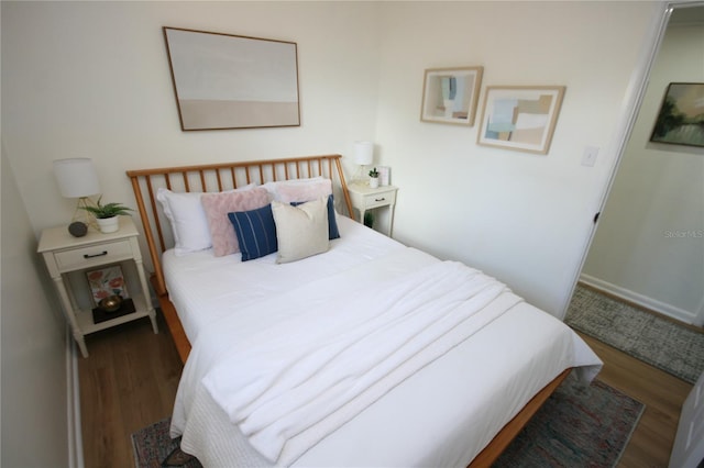bedroom featuring baseboards and wood finished floors