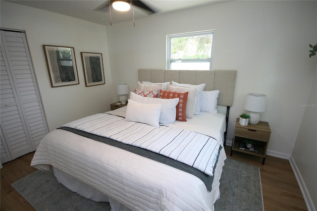 bedroom with baseboards, a ceiling fan, a closet, and wood finished floors