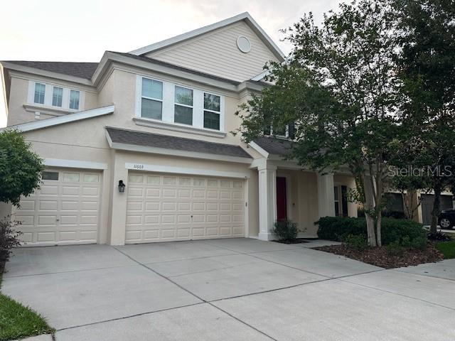 view of front facade featuring driveway, stucco siding, and a garage