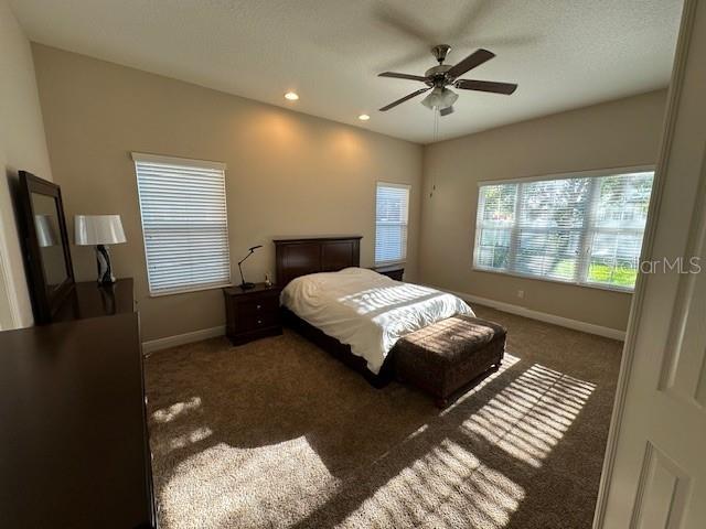 carpeted bedroom with baseboards, ceiling fan, and recessed lighting