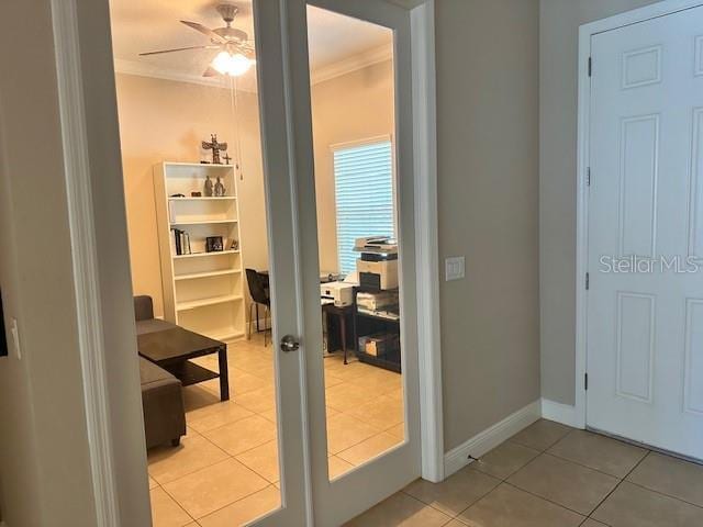 doorway with a ceiling fan, french doors, baseboards, light tile patterned flooring, and crown molding