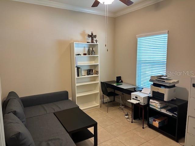home office with crown molding, light tile patterned flooring, and ceiling fan
