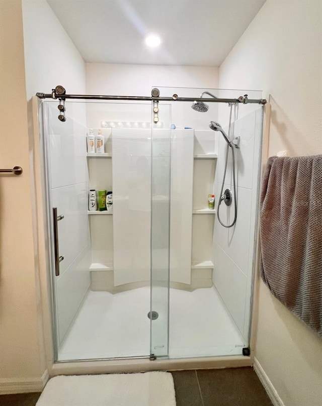 bathroom with a stall shower and baseboards