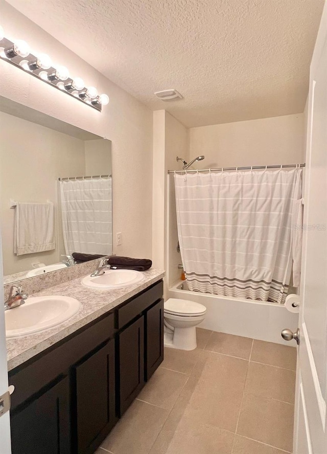 bathroom with shower / bath combination with curtain, double vanity, a textured ceiling, toilet, and tile patterned flooring