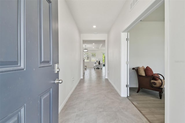 corridor featuring light tile patterned floors, baseboards, recessed lighting, and visible vents