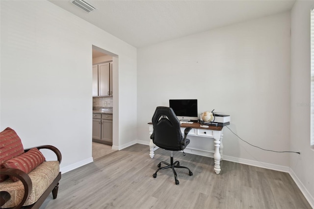 office featuring baseboards, visible vents, and light wood-style flooring