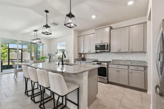 kitchen featuring stainless steel appliances, gray cabinets, visible vents, and a sink