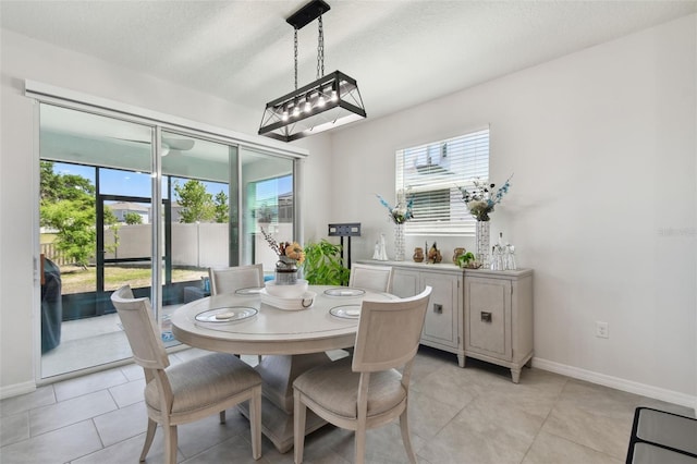 dining space with baseboards, light tile patterned flooring, and a wealth of natural light