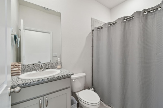 bathroom featuring toilet, a shower with shower curtain, and vanity