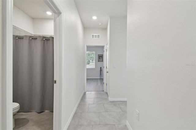 hall featuring baseboards, recessed lighting, light tile patterned flooring, and visible vents