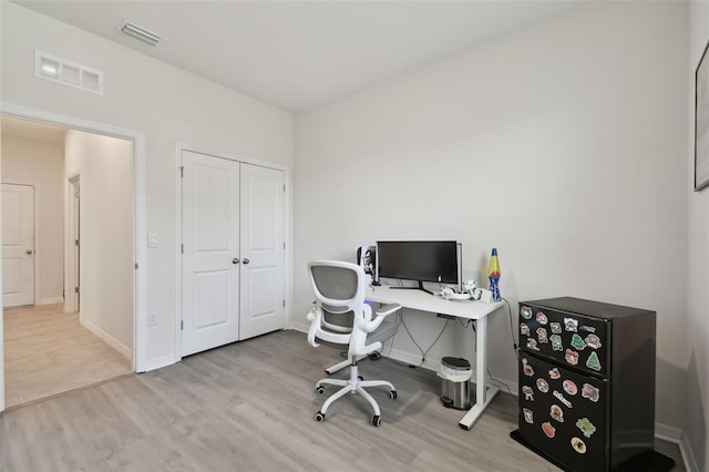 home office with visible vents, baseboards, and wood finished floors