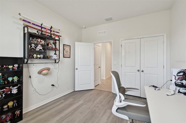 office featuring baseboards, visible vents, and light wood finished floors