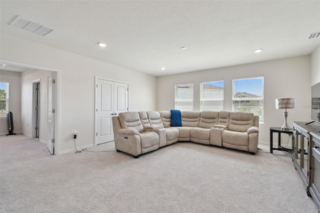 living area with visible vents, recessed lighting, baseboards, and light colored carpet