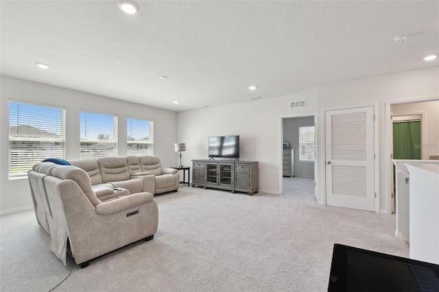 living room featuring light colored carpet, a textured ceiling, recessed lighting, baseboards, and visible vents