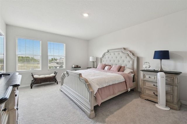 bedroom featuring light colored carpet and baseboards