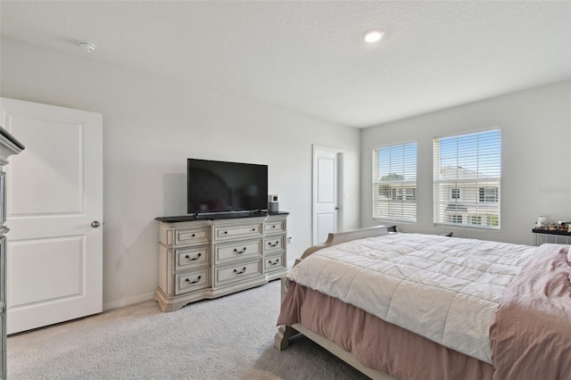 bedroom with a textured ceiling, baseboards, and carpet