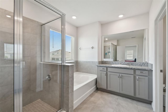full bathroom featuring vanity, toilet, tile patterned floors, a shower stall, and a garden tub