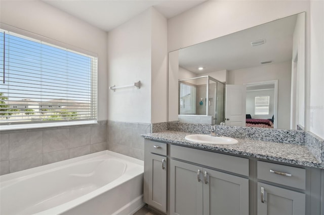 ensuite bathroom featuring vanity, a garden tub, ensuite bath, and a stall shower