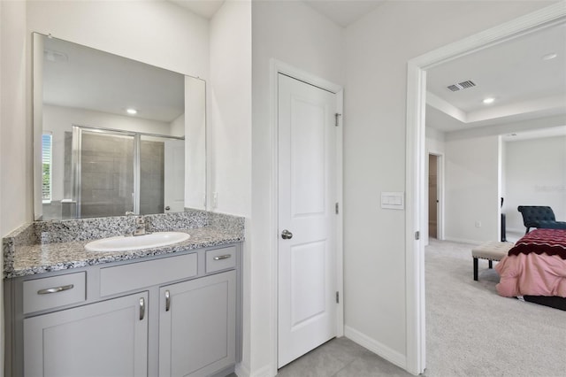 ensuite bathroom with visible vents, baseboards, a stall shower, and vanity