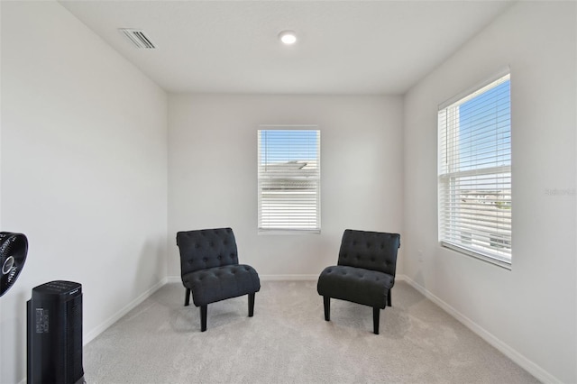 sitting room featuring carpet flooring, baseboards, visible vents, and plenty of natural light