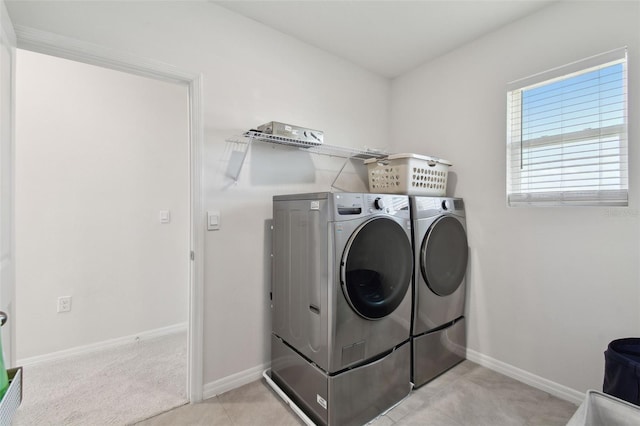 washroom featuring baseboards, laundry area, and washer and dryer