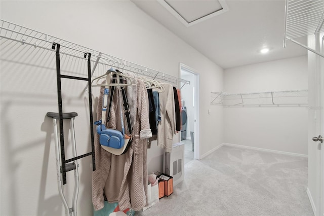 spacious closet featuring carpet flooring, attic access, and washer / clothes dryer