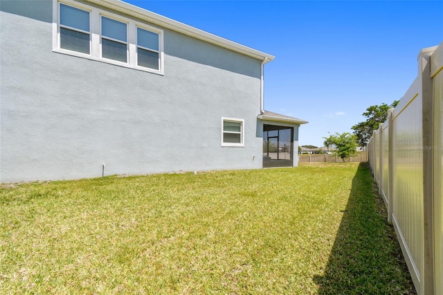 view of yard featuring a sunroom and a fenced backyard