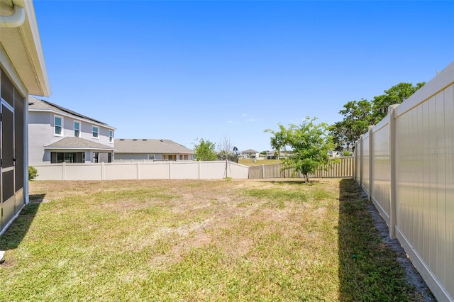 view of yard with a fenced backyard and a residential view