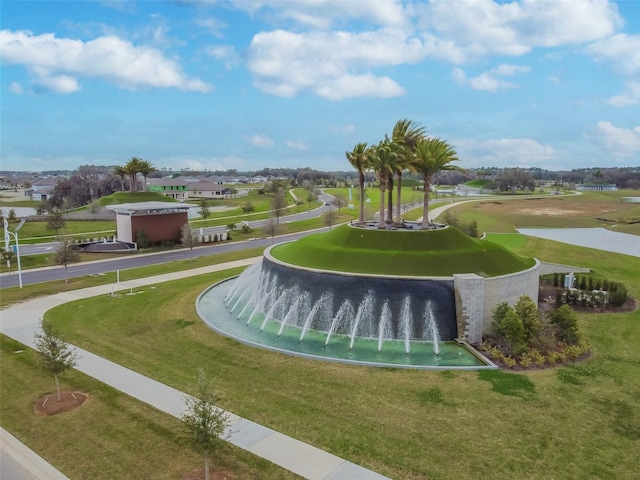 view of property's community featuring a lawn and a water view