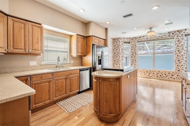 2704 Chambray Ln, Tampa, FL 33611 - kitchen with appliances with stainless steel finishes, a sink, light wood-type flooring, a center island, and light countertops