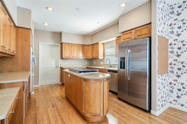 2704 Chambray Ln, Tampa, FL 33611 - kitchen with stainless steel appliances, wallpapered walls, light wood finished floors, a sink, and light countertops