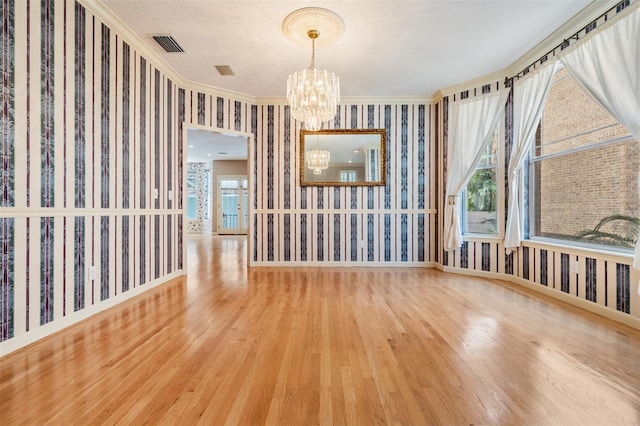 2704 Chambray Ln, Tampa, FL 33611 - empty room featuring wallpapered walls, a chandelier, wood finished floors, ornamental molding, and baseboards