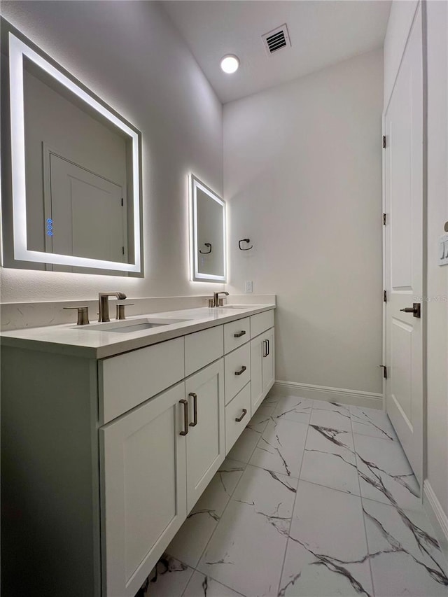bathroom featuring a sink, baseboards, marble finish floor, and visible vents