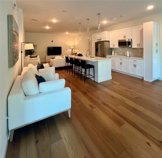 living area with recessed lighting and wood finished floors