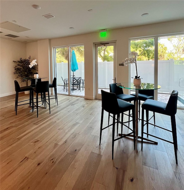 dining space featuring baseboards, light wood-type flooring, and visible vents