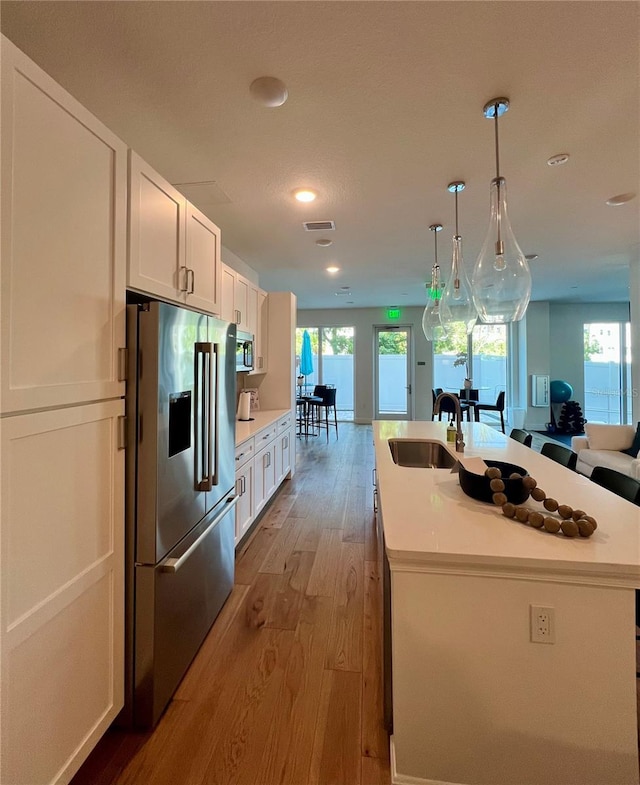 600 3rd Ave S Unit 503, Saint Petersburg, FL 33701 - kitchen featuring appliances with stainless steel finishes, a sink, light wood-style flooring, white cabinets, and recessed lighting