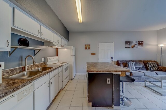 kitchen with a sink, open floor plan, white cabinetry, white appliances, and a kitchen island