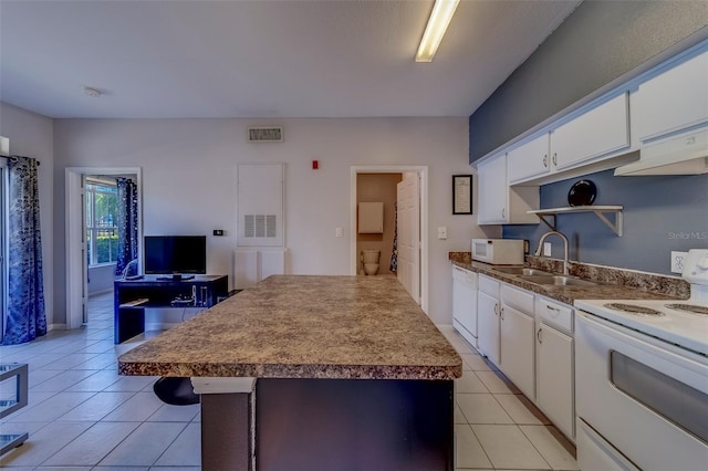 kitchen featuring visible vents, light tile patterned floors, a sink, white appliances, and white cabinetry